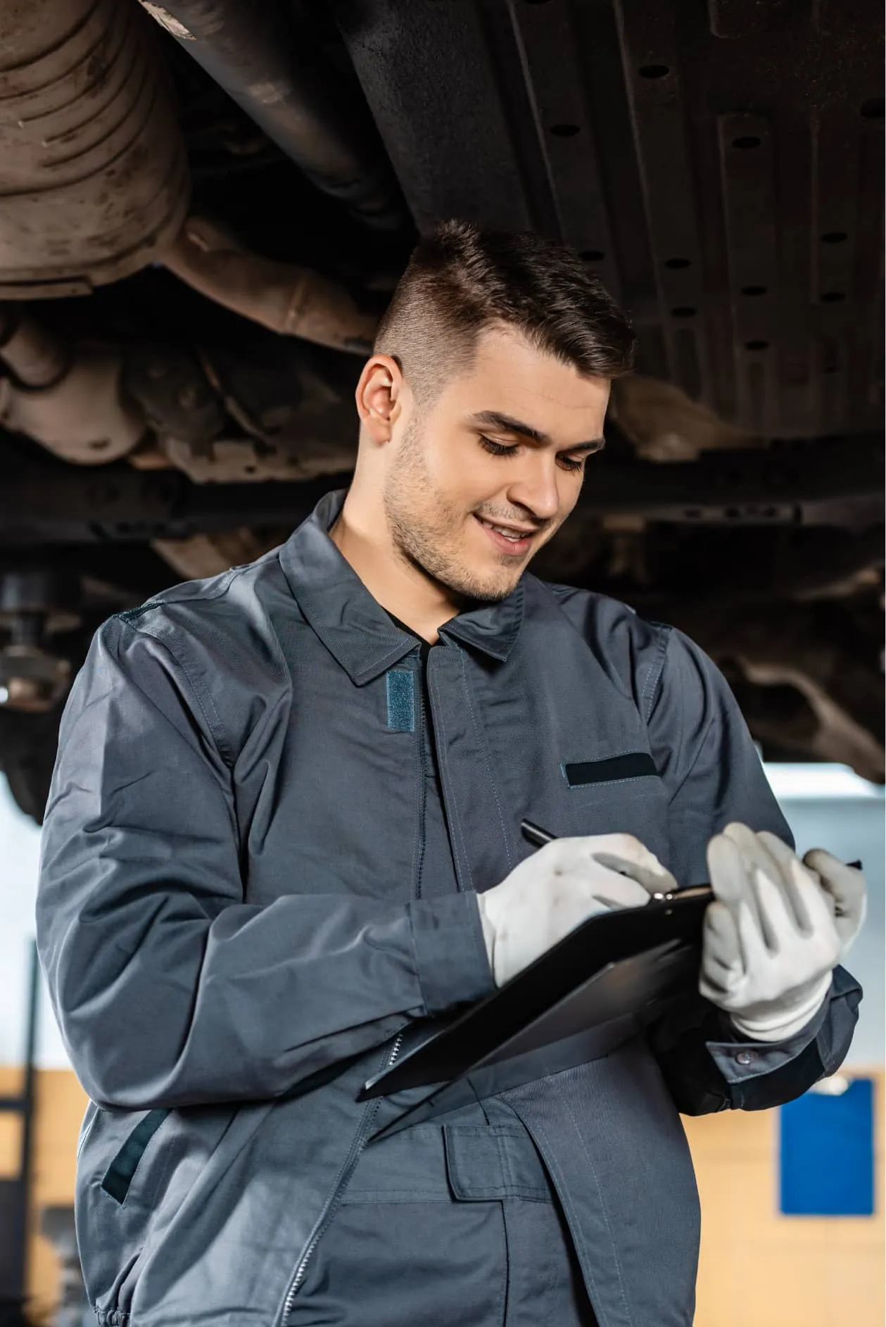 Panmech technician checking a repair sheet under a vehicle